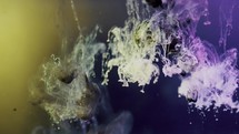 Black and purple paint ink exploding underwater with yellow background light	