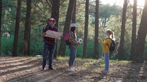 Family on hike. Happy family open map planning a hiking adventure. Group of family travelers in pine forest consulting about the directions with a map. Travel vacations. Family hiking trek concept.