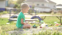 Boy plays sand toys outdoors. Little sweet boy playing in sandbox on playground. Child playing in the sandbox with toy. Happy family healthy children concept.