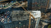 High crane works on building site with a house. Urban Construction Site, Aerial View. 
