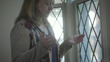 a woman praying at a window 