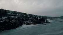 drone flying over a winter shoreline 