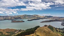 Sunny landscape with clouds over sea bay and mountains in New Zealand nature Time lapse
