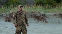 Man with military uniform walks in the beach