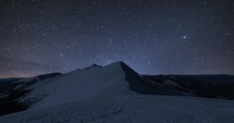 Starry night sky stars milky way galaxy motion fast over winter alps mountains in frozen snowy nature Astronomy Time lapse 4k uhd