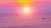 Sunset above the sea surface with sail boats, aerial view.