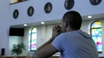 a man in prayer in a church 