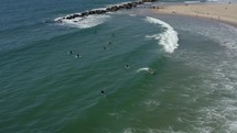 Bird's eye view of surfer carving and riding shortboard in shorebreak wave, aerial. 