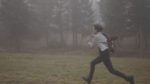 a man running in a misty forest 