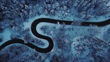 aerial view over a curvy road in snow 