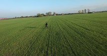 a man walking through a field in a suit 