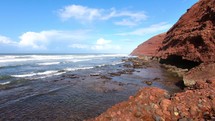 Slow motion of ocean waves in rocky coast in sunny summer day in Morocco nature landscape
