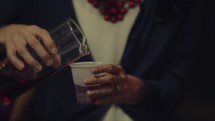 pouring communion wine into cups 