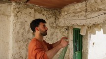 Young Man Hangs Clothes In An Old House In Calabria