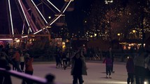 ferris wheel and ice skating rink at night 