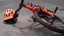 An orange bicycle and helmet in the driveway - tracking right and left motion with room for graphics