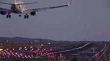 Airplane landing on a runway at night.