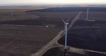 Aerial drone shot of Wind Turbine Generating Sustainable Energy At a Farm.