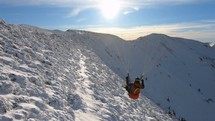 Proximity paragliding flight over snowy alpine mountains, Freedom adrenaline adventure
