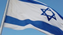 Flag of Israel waving against blue sky