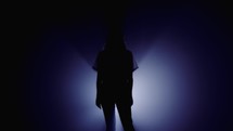 girl standing in a colored spotlight 