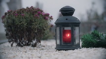 Red candle lantern on the grave. Funeral atmosphere.
