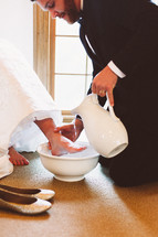 a groom washing his brides feet 