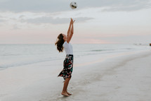 a woman on a beach with a volleyball 