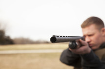 a man pointing a shot gun 