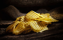 crispy Potato chips on rustic wooden table