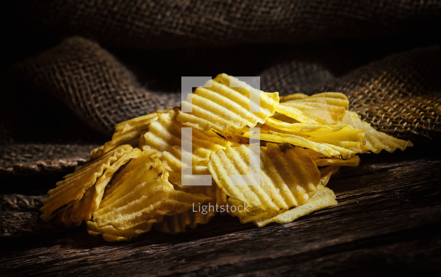 crispy Potato chips on rustic wooden table