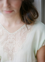 woman in a lace top looking down 