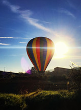 Colorful hot air balloons taking off with sunlight behind, Tuscany in Italy.