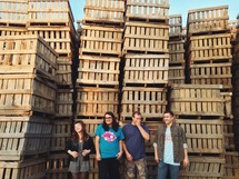 young adults standing in front of wood crates 