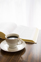 coffee cup and opened Bible on a table 