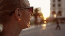Smiling woman in sunglasses outdoor during sunset