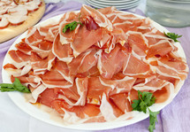 Plate with slices of ham on buffet table.