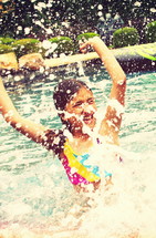 girl child splashing in a pool