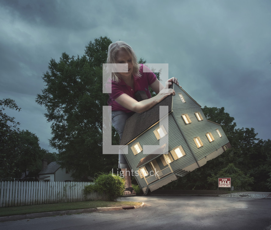A large woman picks up a house by the roof.