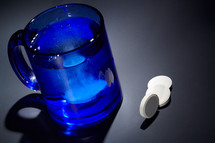 Tablet dissolving in a blue glass of water