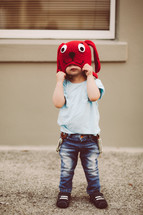 a toddler boy in a red knit dog hat 