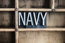 word Navy in blocks on a bookshelf 