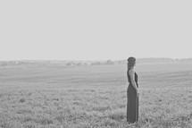 woman standing in an open field 