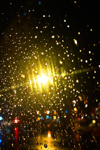 Lights shining through raindrops on a window.