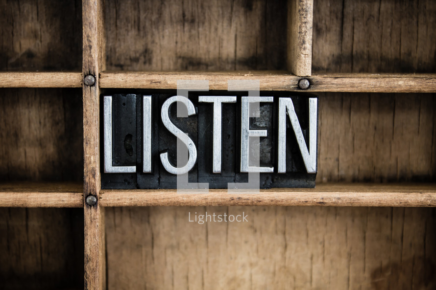 word listen in blocks on a bookshelf 