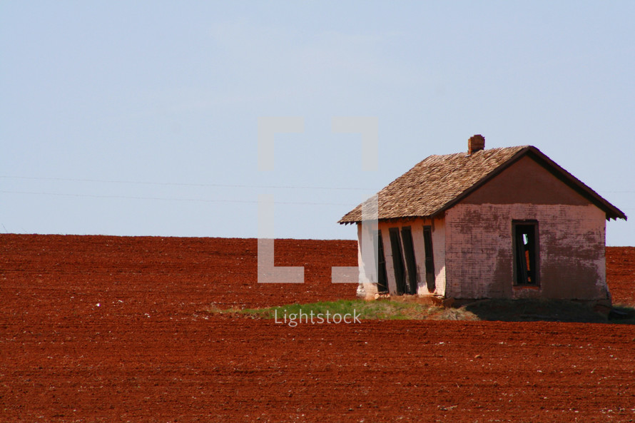 old barn in a red dirt field 