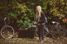 blonde woman standing next to a bicycle 