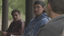 young men discussing scripture on a cabin porch 