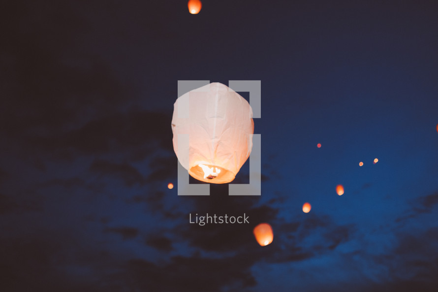 paper lanterns floating in the night sky