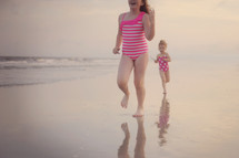 young girls running on a beach 